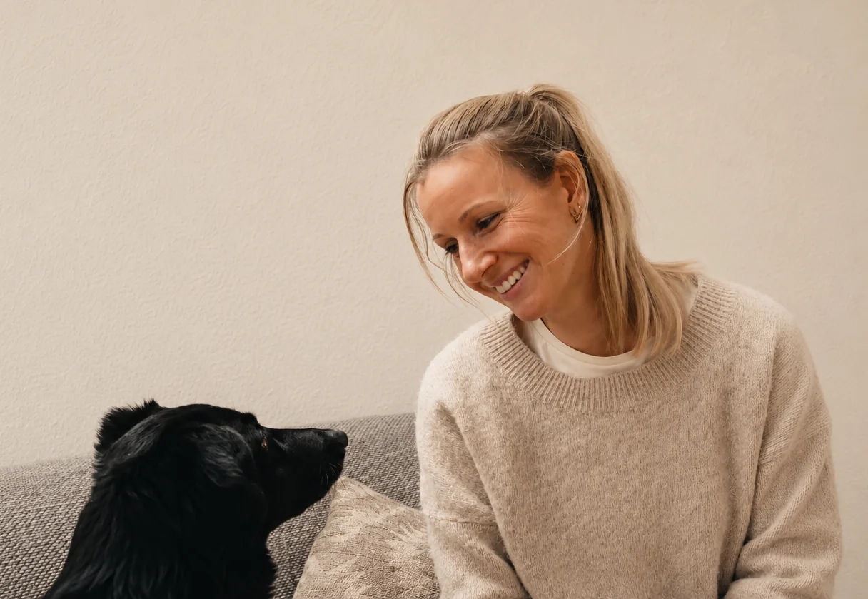 Sylvia Schreiber, Hundephysiotherapeutin in Neuss, lächelt einen schwarzen Hund an, der ihr aufmerksam entgegensieht